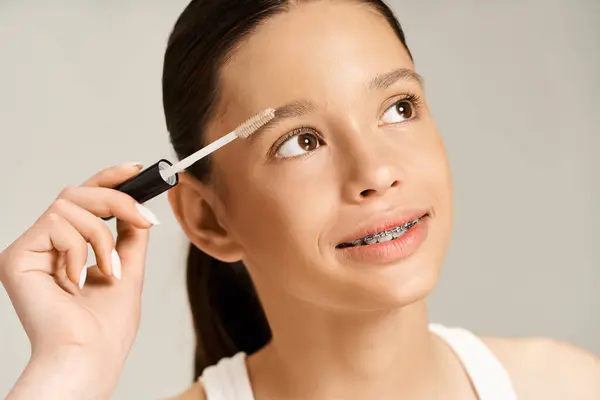 A stylish teenage girl energetically taking care of her eyebrows. — Stock Photo