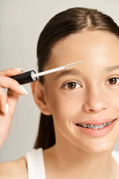 A trendy teenage girl energetically taking care of her eyebrows. — Stock Photo