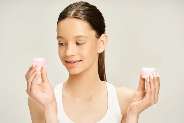 Une adolescente élégante tient énergiquement la crème dans ses mains. — Photo de stock