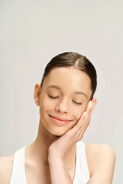 A young woman in vibrant attire closes her eyes and tenderly rests her hand on her face, exuding a sense of peace and introspection. — Stock Photo