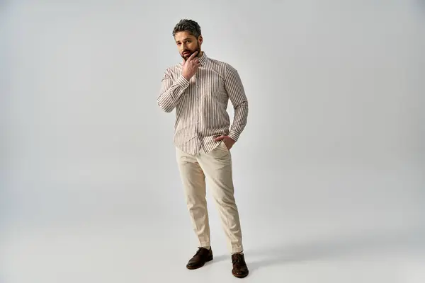 Бородатий чоловік в елегантному вбранні стоїть перед білим тлом — стокове фото
