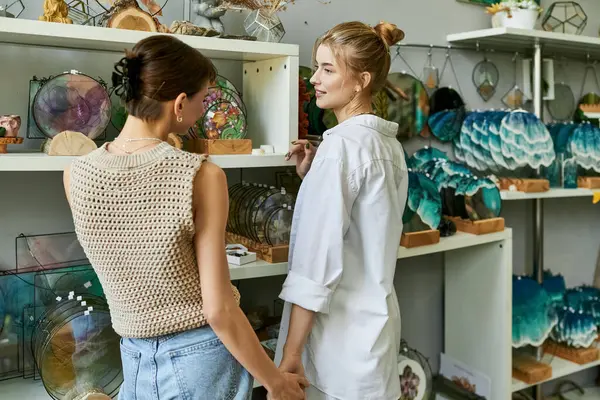 Two women in an art studio, standing together with love and tenderness. — Stock Photo