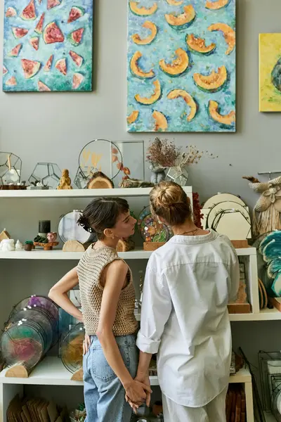 Two women in an art studio, sharing a tender moment. — Stock Photo