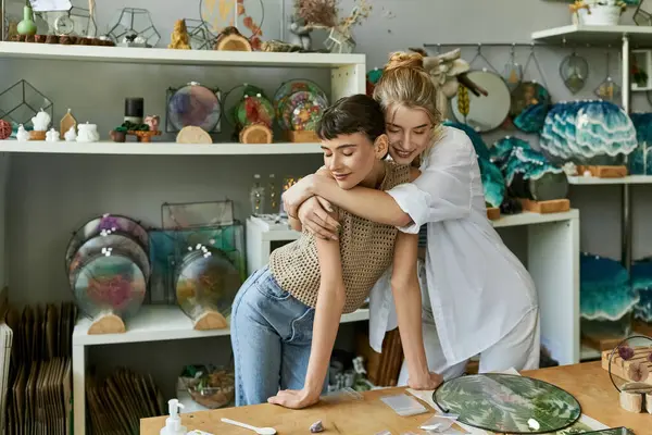 Ein zärtlicher Moment zwischen zwei Frauen, die sich in einem Kunstladen umarmen. — Stockfoto