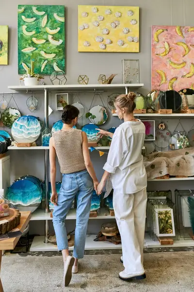 Loving, artistic lesbian couple standing together in cozy art studio. — Stock Photo