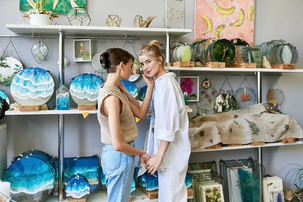 Two artistic women embrace in an art studio. — Stock Photo