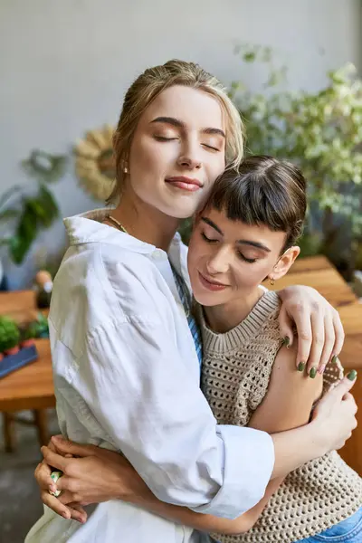 Due donne che condividono un abbraccio sincero in uno studio d'arte. — Foto stock