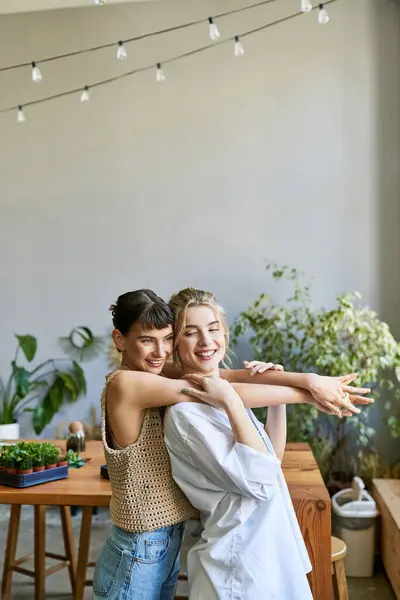 Una coppia lesbica amorevole sta insieme in uno studio d'arte, condividendo un momento speciale. — Foto stock