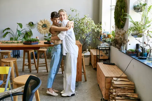 Una pareja lesbiana cariñosa, dos mujeres, en un estudio de arte - foto de stock