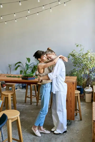 Две женщины, любящая нежная лесбийская пара, обнимаются в художественной студии. — стоковое фото