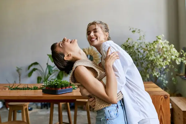 A loving, tender lesbian couple standing together in an art studio. — Stock Photo