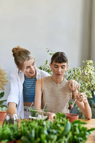 Lesbian couple immersed in creative conversation at art studio table. — Stock Photo