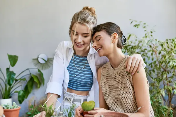 Two women, a loving lesbian couple, collaborate at an art studio table. — Stock Photo
