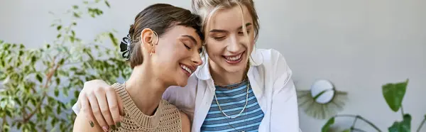 Two arty women, a loving lesbian couple, standing together at an art studio. — Stock Photo