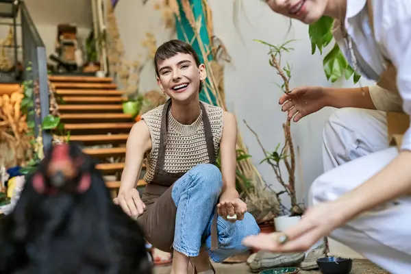 Two women sitting on the floor with a hen in an art studio — Stock Photo