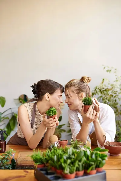 Two women sitting closely, sharing a moment of love and connection in an art studio. — Stock Photo