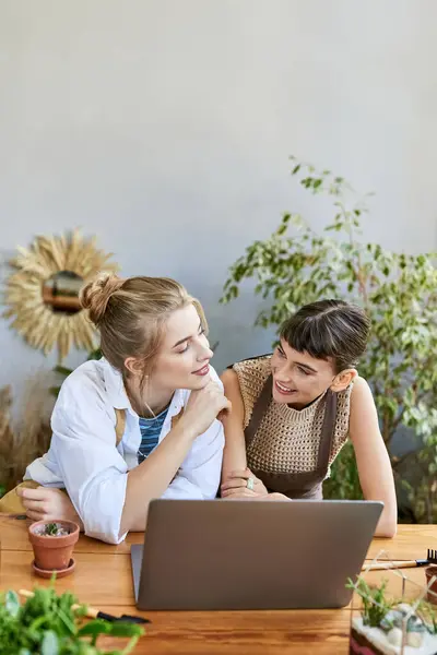 Two women immersed in creativity, working together on a laptop in an art studio. — Stock Photo