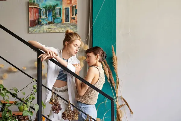 Deux jeunes femmes, immergées dans un moment artistique, se tiennent sur les marches d'une maison. — Photo de stock