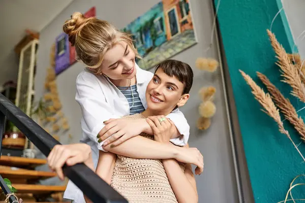 Woman hugs her girlfriend on staircase. — Stock Photo