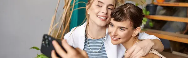 A woman and her girlfriend pose for a selfie in an art studio. — Stock Photo