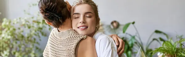 A loving lesbian couple hugging tenderly in an art studio. — Stock Photo