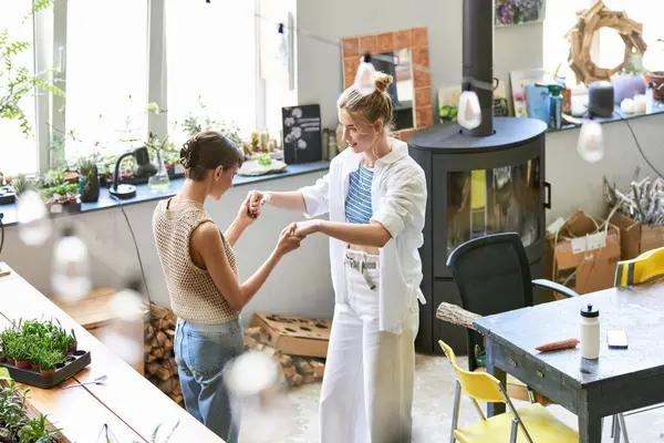 Two women, a loving lesbian couple, standing in an art studio. — Stock Photo