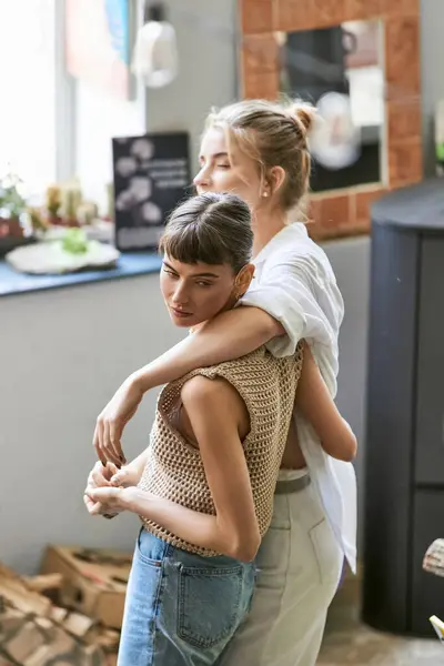 Due donne che condividono un abbraccio amorevole in uno studio d'arte. — Foto stock