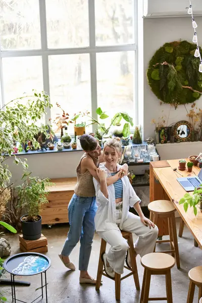 A loving, tender lesbian couple standing side by side in an art studio. — Stock Photo