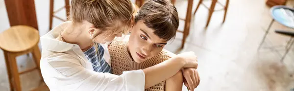 Two women, a loving tender lesbian couple, hugging each other in an art studio. — Stock Photo