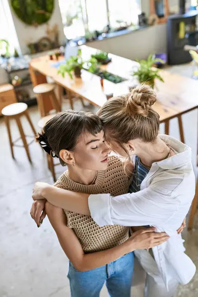 Due donne si abbracciano calorosamente in un ambiente accogliente cucina. — Foto stock