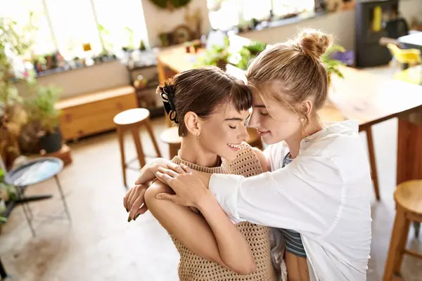 Two women, a loving and tender lesbian couple, stand together at an art studio. — Stock Photo