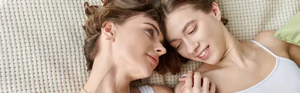 A beautiful lesbian couple in comfy attire, laying peacefully side by side on a bed. — Stock Photo