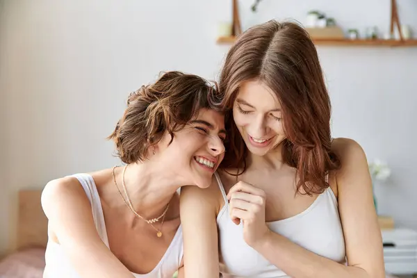 Two women in cozy attire sitting on bed, sharing a moment of connection and intimacy. — Stock Photo