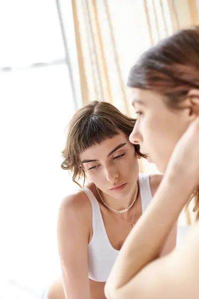 Two pretty women in a bedroom, looking at each other warmly. — Stock Photo