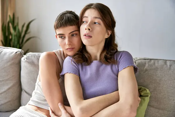 Two women in comfy clothing, sitting on top of a couch. — Stock Photo