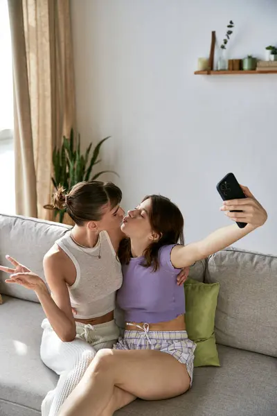 Zwei Frauen auf einer Couch und machen ein Selfie. — Stockfoto