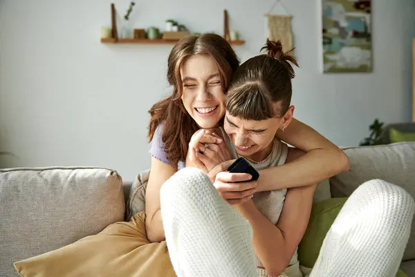 A beautiful lesbian couple in comfy attire relaxing together on a couch. — Stock Photo