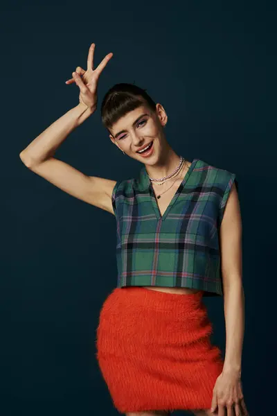 A woman strikes a stylish pose with her hand raised. — Stock Photo