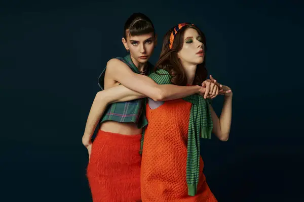 Two women in orange skirts hugging affectionately. — Stock Photo