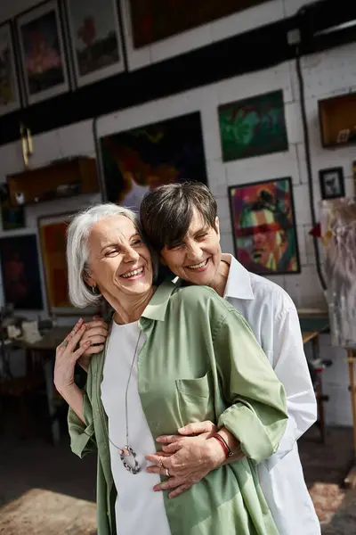 A mature lesbian couple hugging lovingly in studio. — Stock Photo