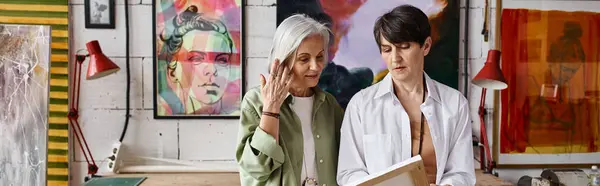Dos mujeres admiran las pinturas en una acogedora habitación llena de arte. - foto de stock