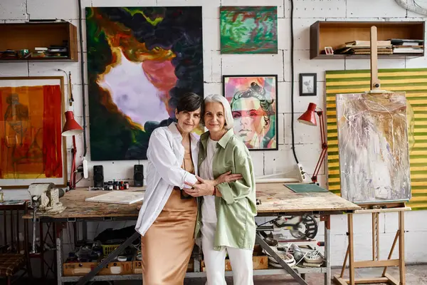 Zwei reife Frauen, ein lesbisches Paar, stehen nebeneinander in einem Kunstatelier. — Stockfoto
