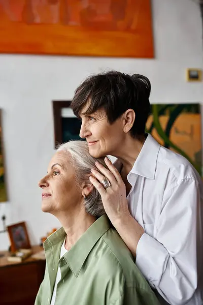 Eine Frau, die von einer anderen Frau in einem leuchtend grünen Hemd umarmt wird. — Stockfoto