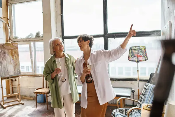 Mature lesbian couple happily painting together in art studio. — Stock Photo