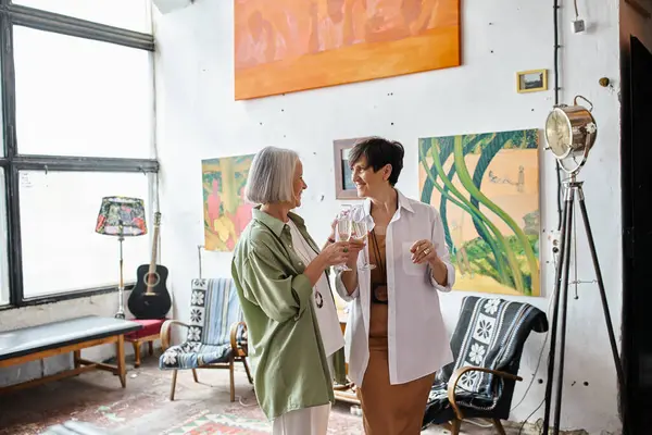 Mature lesbian couple standing in art studio. — Stock Photo