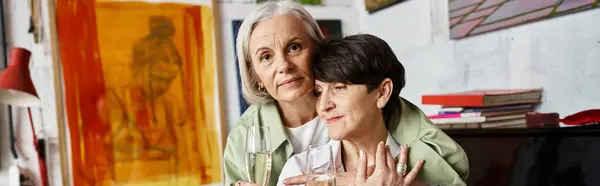Two women holding glasses of wine in a cozy setting. — Stock Photo