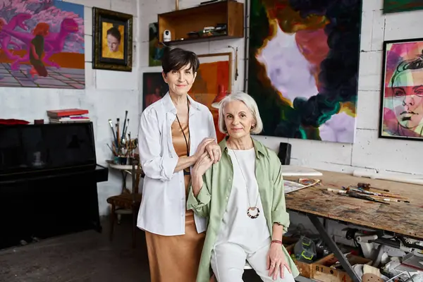 Two women stand together in an art studio. — Stock Photo