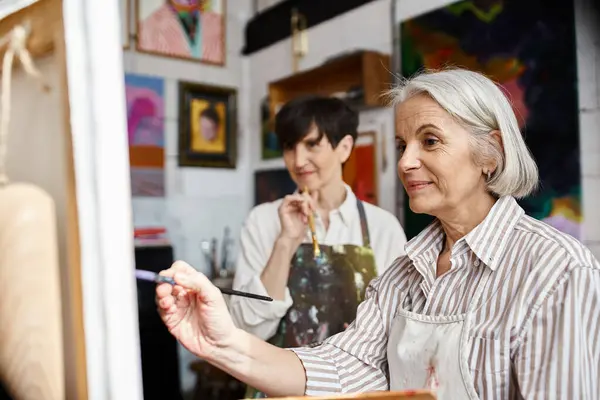 Woman holding paintbrush in front of her partner. — Stock Photo