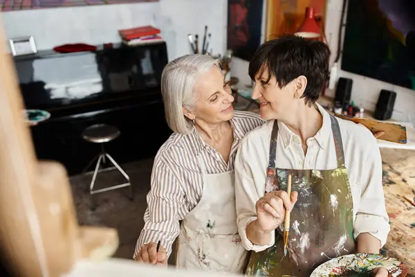 Mature lesbian couple working together in an art studio. — Stock Photo