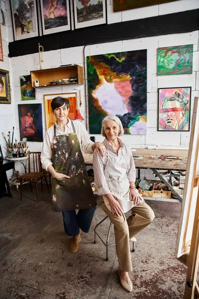 Maturo lesbiche coppia ammirando dipinti in accogliente stanza. — Foto stock